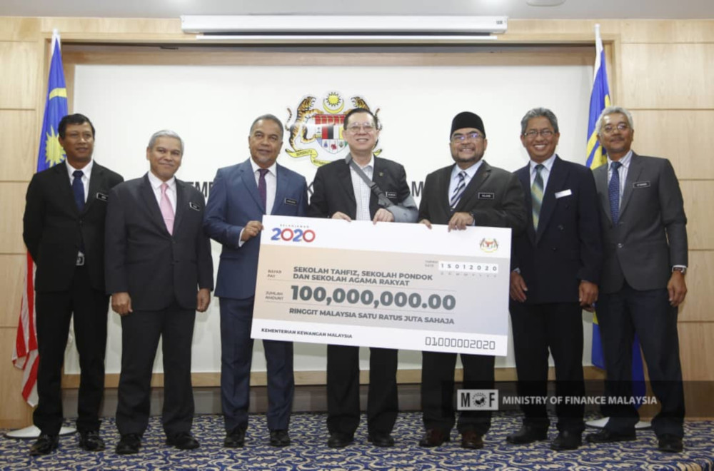 Finance Minister Lim Guan Eng hands over the RM100 million allocation to Minister in the Prime Ministeru00e2u20acu2122s Department Datuk Seri Mujahid Yusof at the Finance Ministry in Putrajaya January 15, 2020. u00e2u20acu201d Picture from Twitter/Ministry of Finance
