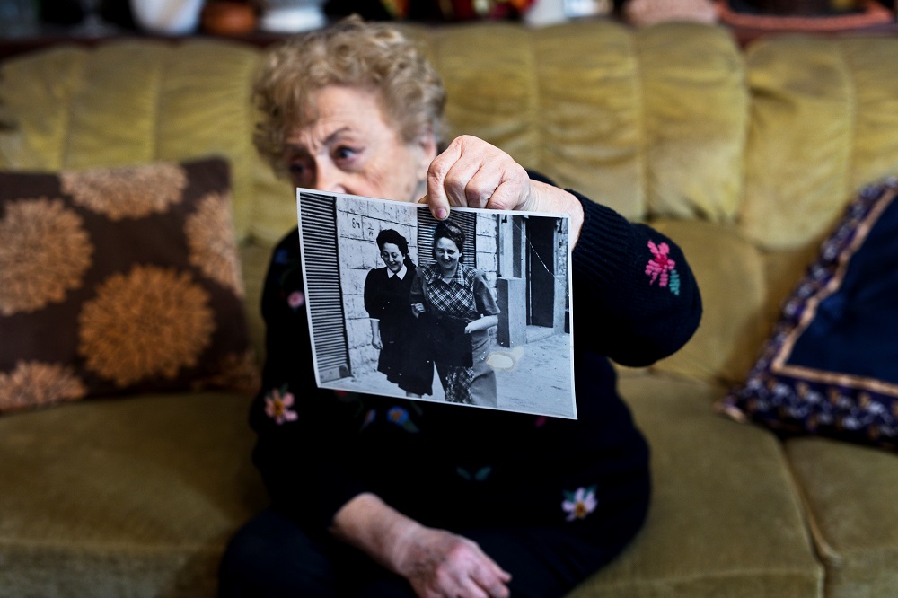 Jona Laks, survivor of Dr Josef Mengele's twins experiments shows a photo of her and her older sister Chana, during an interview in her house in Tel Aviv, Israel January 21, 2020. — Reuters pic