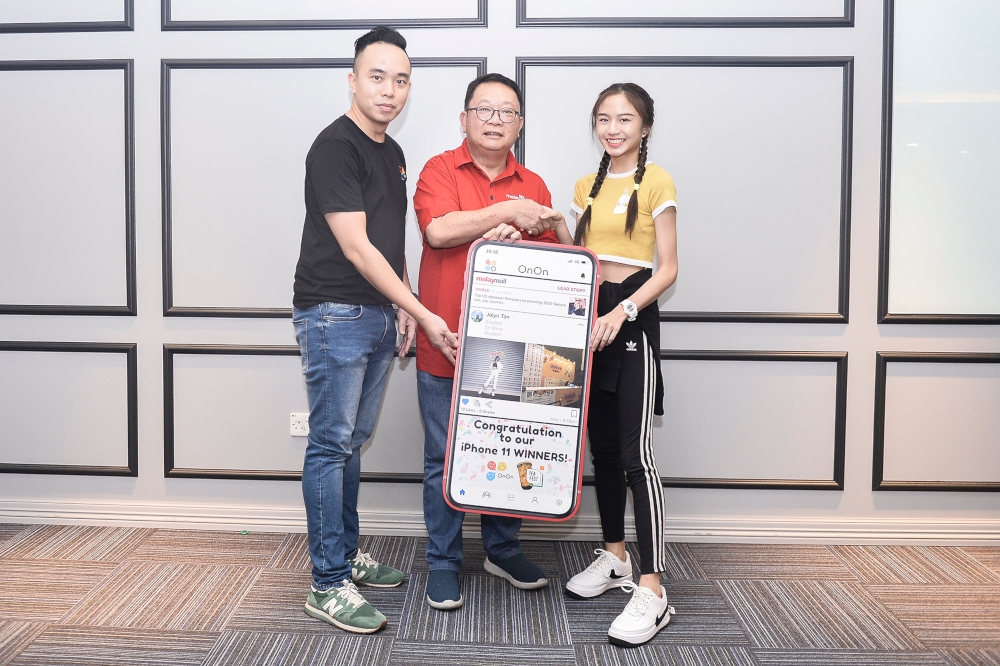 OnOn co-founder Chow Kim San (left) and Malay Mail editor-in-chief Datuk Wong Sai Wan presenting Tan with the iPhone 11. — Picture by Miera Zulyana