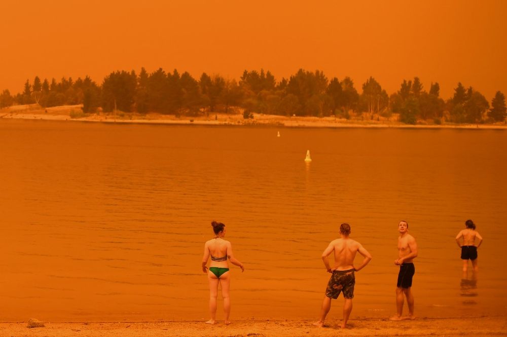 Residents take a dip to cool down at Lake Jindabyne, under a red sky due to smoke from bushfires, in the town of Jindabyne in New South Wales on January 4, 2020. u00e2u20acu201d AFP pic