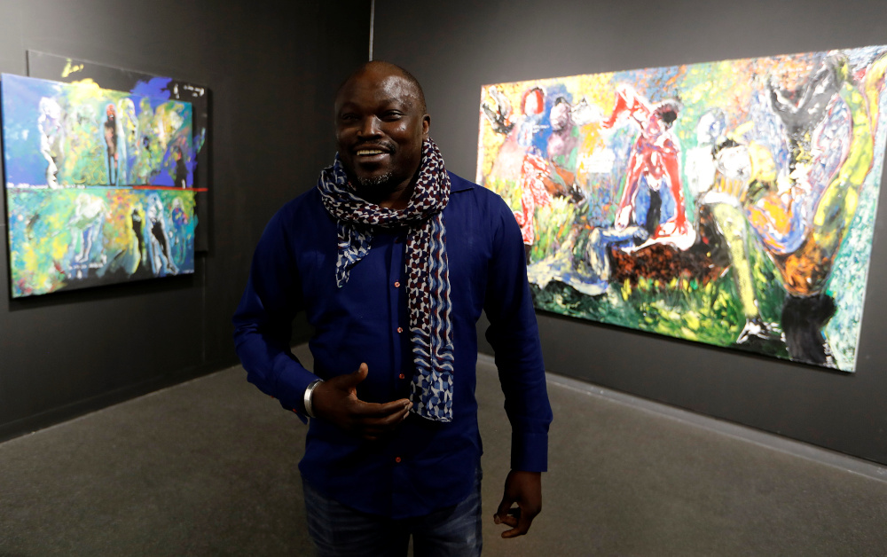 Senegalese artist Soly Cisse speaks during an interview with Reuters, in front of his paintings exhibited at ‘Lend Me Your Dream’ in Dakar, Senegal January 13, 2020. — Reuters pic