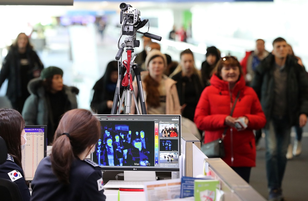 In this picture taken on January 21, 2020 a quarantine officer (bottom) monitors a thermal scanner as passengers from an international flight arrive at Incheon international airport, west of Seoul. u00e2u20acu201d AFP pic