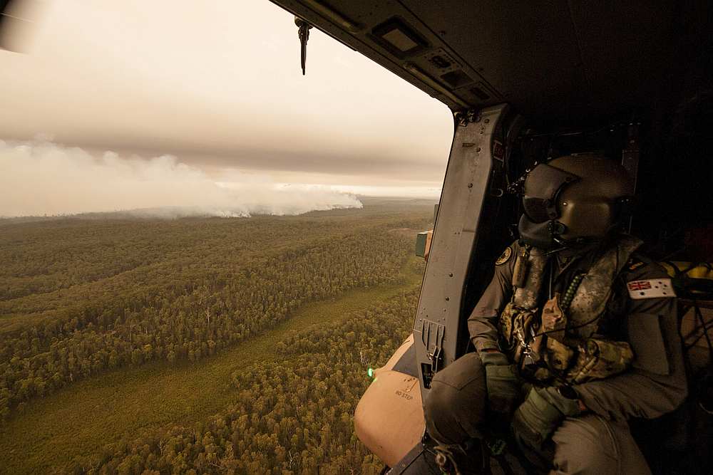 A Royal Australian Navy MRH-90 helicopter crew member, observes the fires on approach to Cann River in Gippsland, Victoria, Australia January 5, 2020. u00e2u20acu201d Private Michael Currie/Australian Department of Defence handout via Reuters
