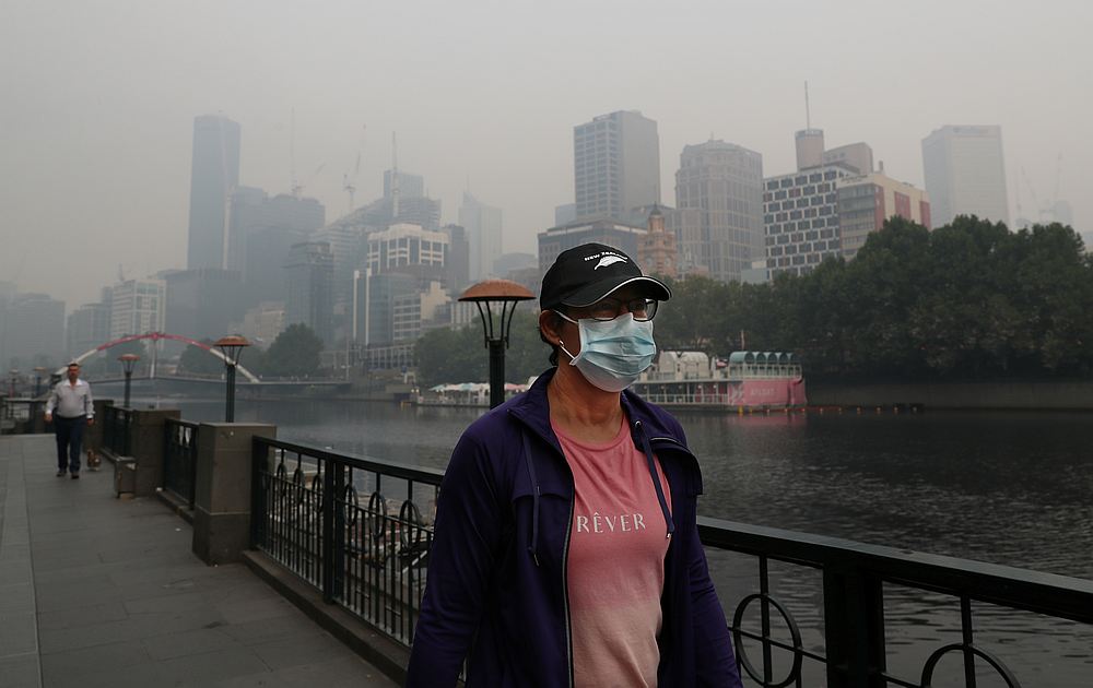 People wear breathing masks to protect themselves from a thick smoke haze from the bushfires, in Melbourne, Australia January 14, 2020. u00e2u20acu201d AAP Image/David Crosling via Reuters