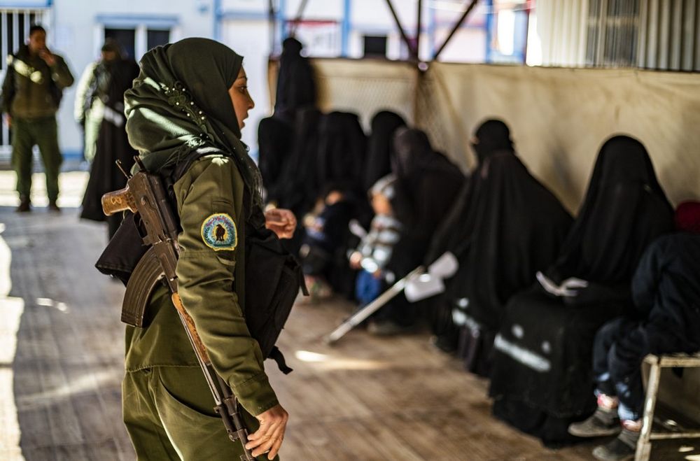 Kurdish fighters watch over women inside the Kurdish-run al-Hol camp for the displaced in the al-Hasakeh governorate in north-eastern Syria on January 14, 2020, at the section reserved for Iraqis and Syrians. u00e2u20acu201d AFP pic