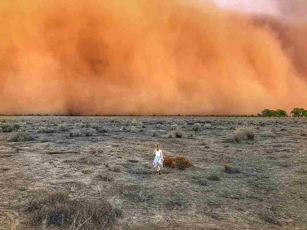 A child running towards a dust storm in Mullengudgery in New South Wales January 20, 2020. u00e2u20acu201d Marcia Macmillan handout via AFP 
