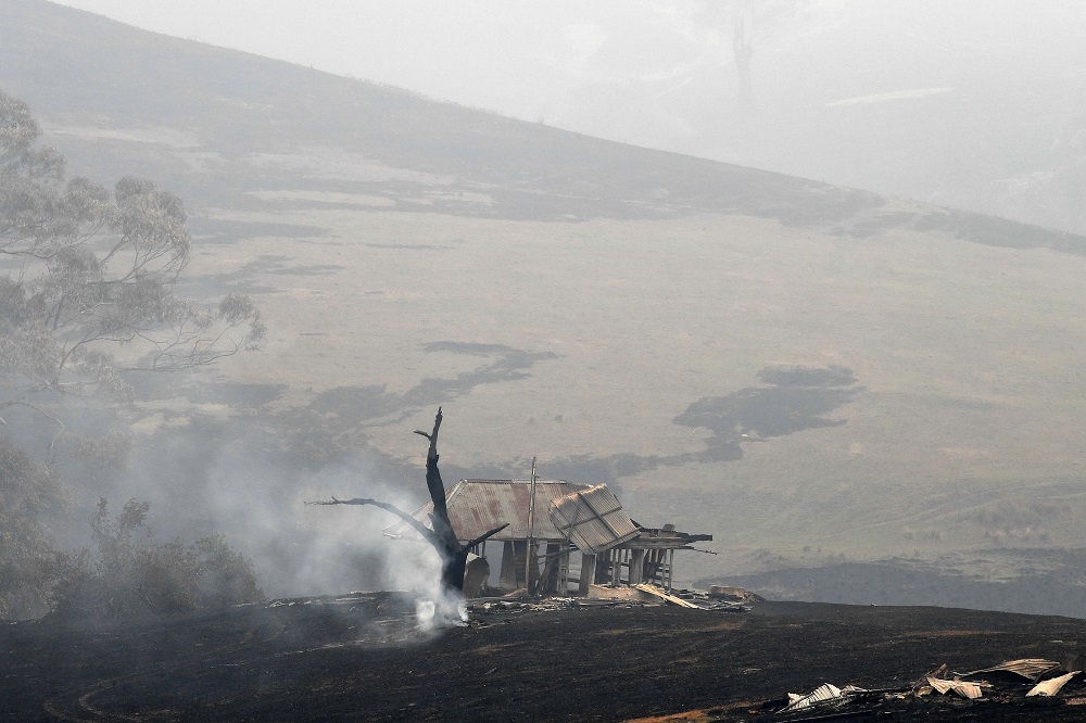 Smoke from a burnt tree rises next to a gutted house in Quaama in Australiau00e2u20acu2122s New South Wales state January 6, 2020. u00e2u20acu201d AFP pic 