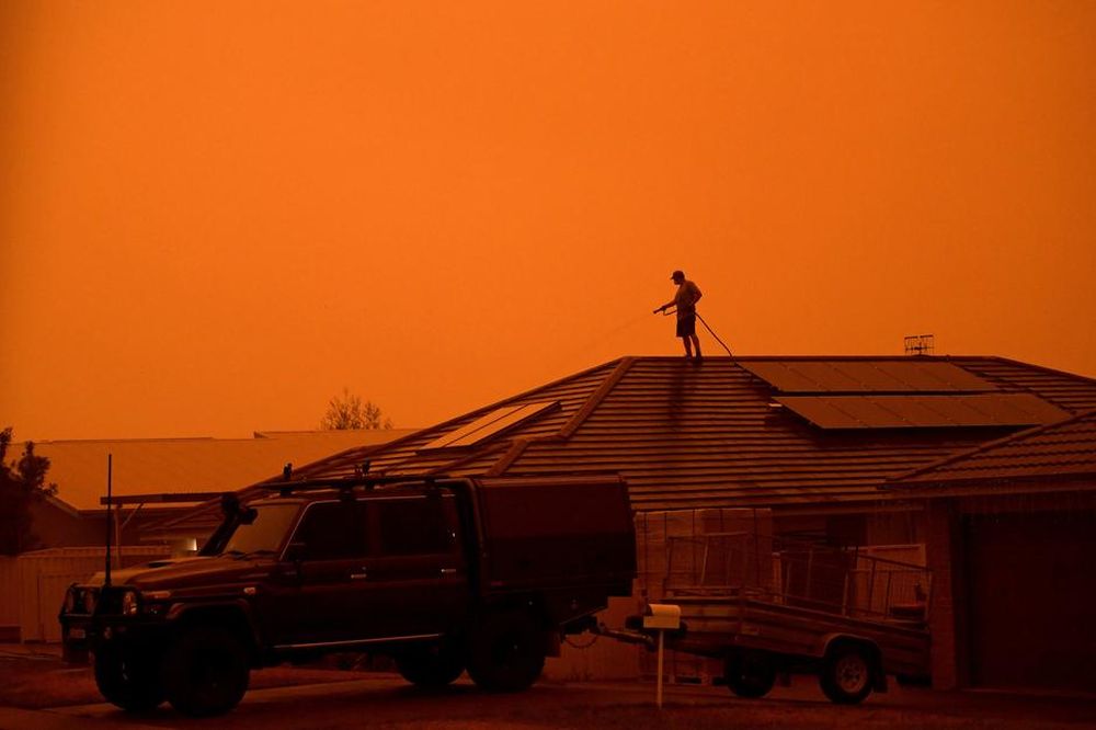 A resident uses a garden hose to wet down the house as high winds push smoke and ash from the Currowan Fire towards Nowra, New South Wales, Australia January 4, 2020. u00e2u20acu201d Reuters pic