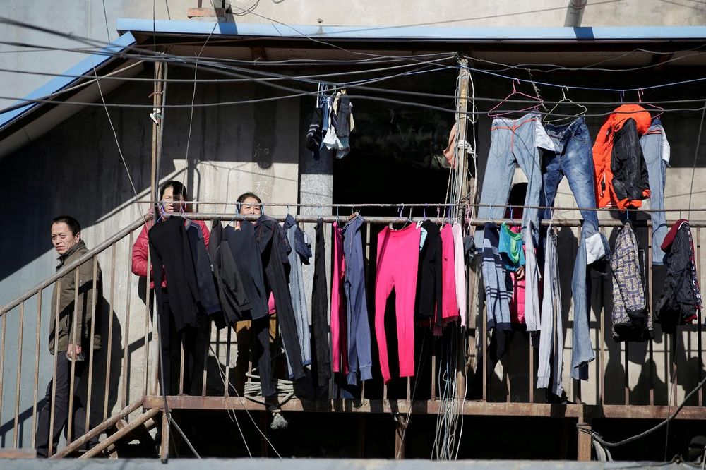 People stand outside a low-cost dwelling at a village, which is mainly inhabited by migrant workers, in Tongzhou district of Beijing, China December 16, 2017. u00e2u20acu201d Reuters pic