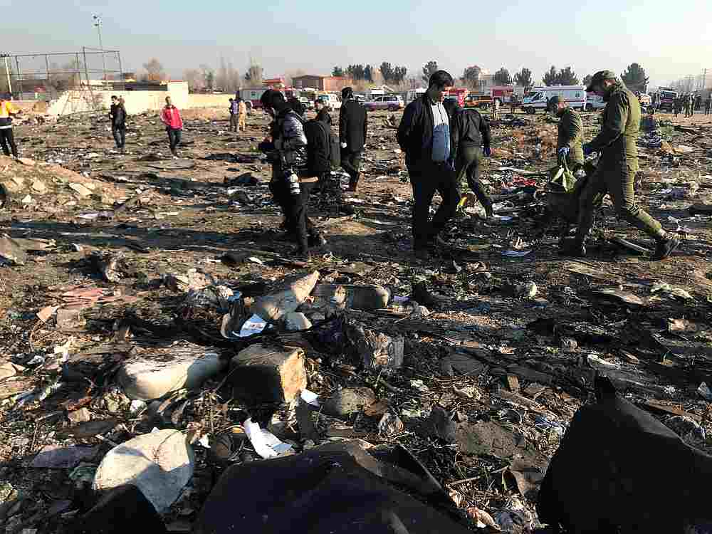 Rescue team members with people check the debris from a plane crash belonging to Ukraine International Airlines after take-off from Iran's Imam Khomeini airport, on the outskirts of Tehran, Iran January 8, 2020. — Wana pic via Reuters