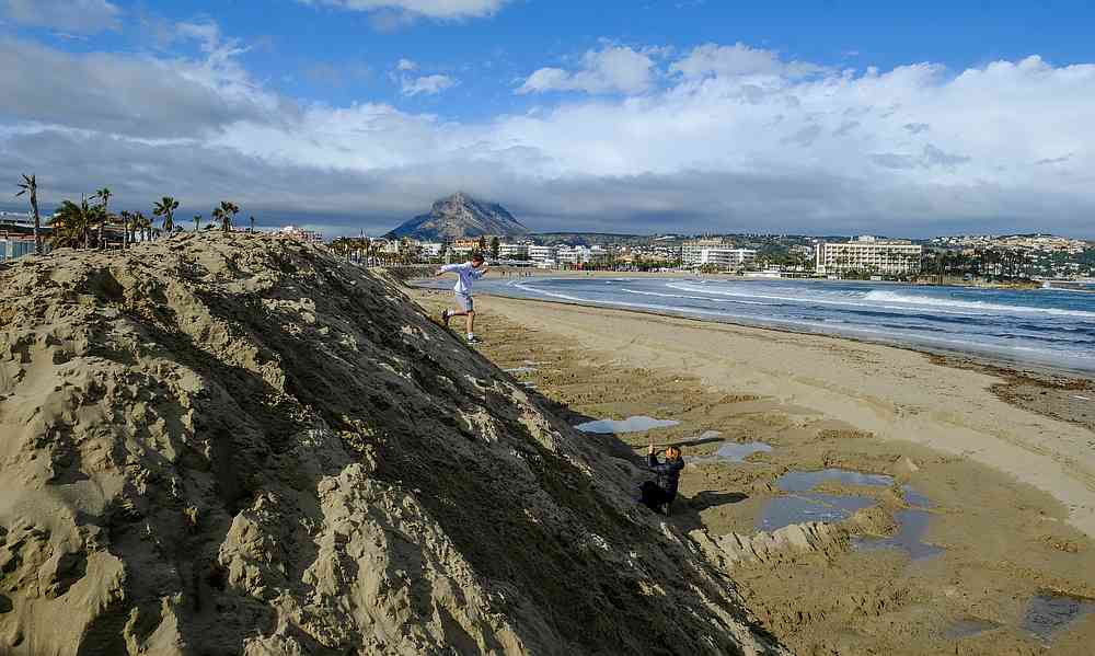People walk past a huge sand shaft built to protect the Arenal Beach ahead of the upcoming storm 'Gloria,' in Javea near Alicante, Spain January 19, 2020. u00e2u20acu201d Reuters pic