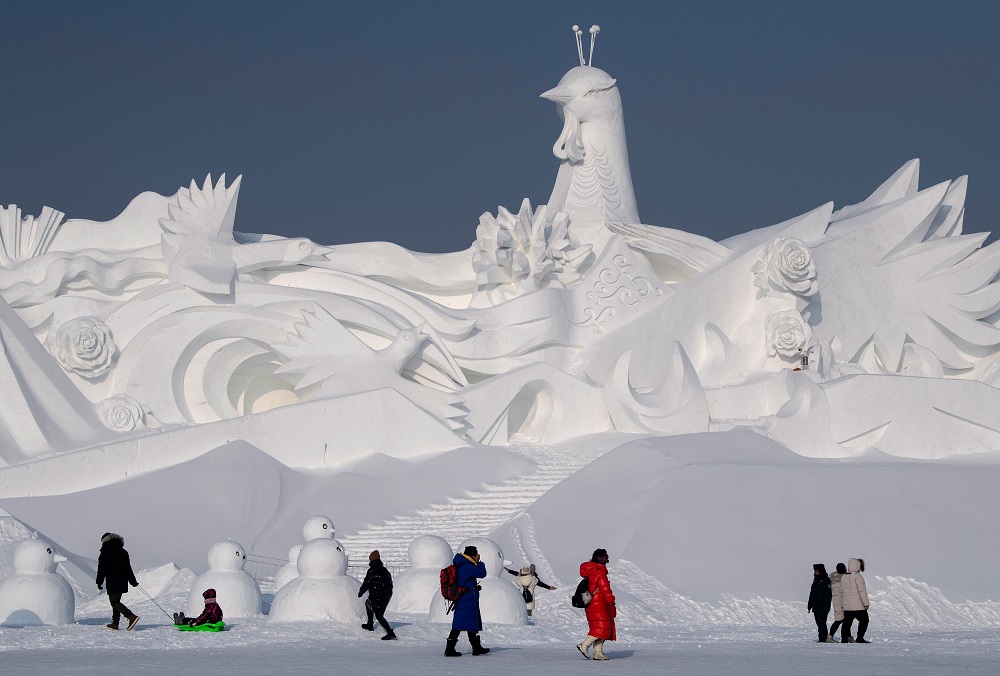 Tourists walk in front of an ice sculpture ahead of the opening of the Harbin International Ice and Snow Festival in Harbin, in China’s northeast Heilongjiang province January 4, 2020. — AFP pic