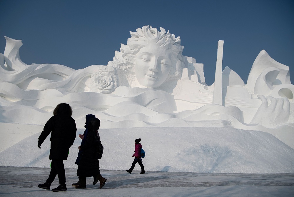 Tourists walk in front of an ice sculpture ahead of the opening of the Harbin International Ice and Snow Festival in Harbin, in China’s northeast Heilongjiang province January 4, 2020. — AFP pic