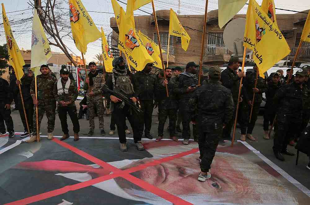 embers of the Hashed al-Shaabi paramilitary force walk above a portrait of US President Donald Trump as they hold a condolences meeting in Karrada in central Baghdad January 6, 2020. u00e2u20acu201d AFP pic