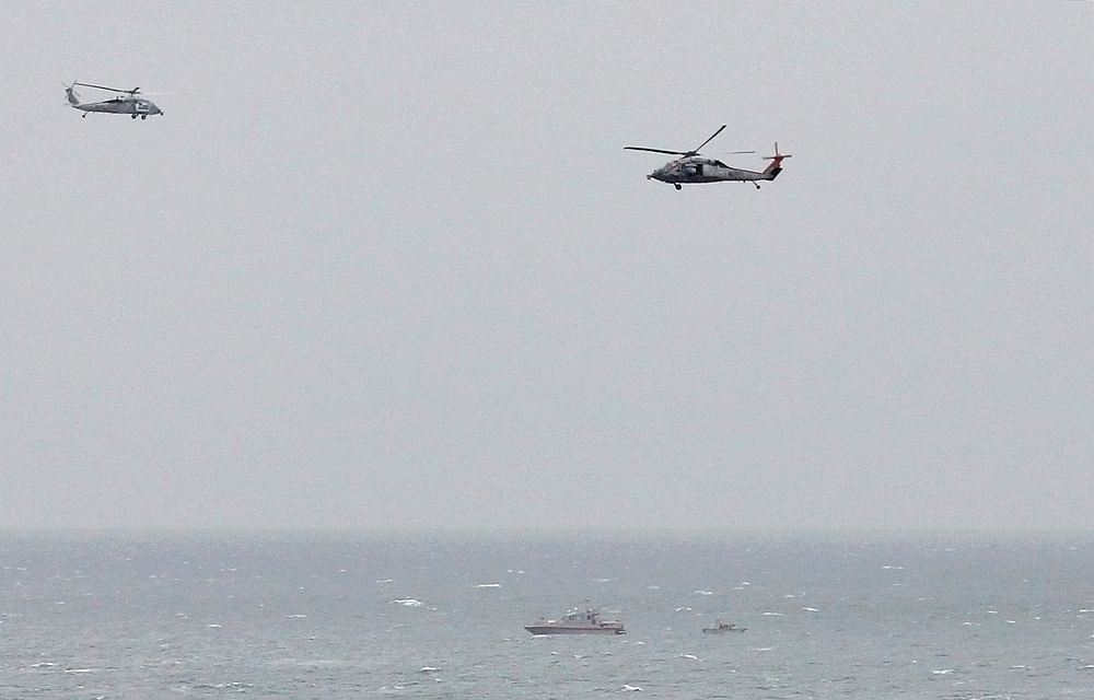 A Iranian Revolutionary Guard boat is seen near a US aircraft carrier in the Strait of Hormuz as US Navy helicopters hover over it March 21, 2017. u00e2u20acu201d Reuters pic