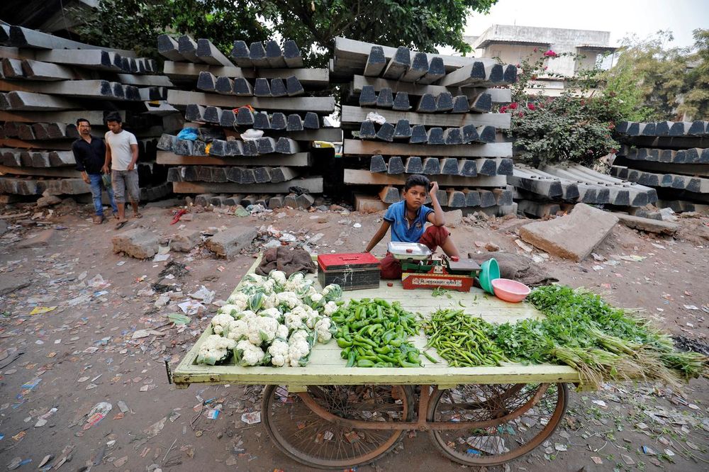 A boy selling vegetables waits for customers in front of construction material for railway tracks, at Navapura on the outskirts of Ahmedabad, India, November 28, 2019. u00e2u20acu201d Reuters pic