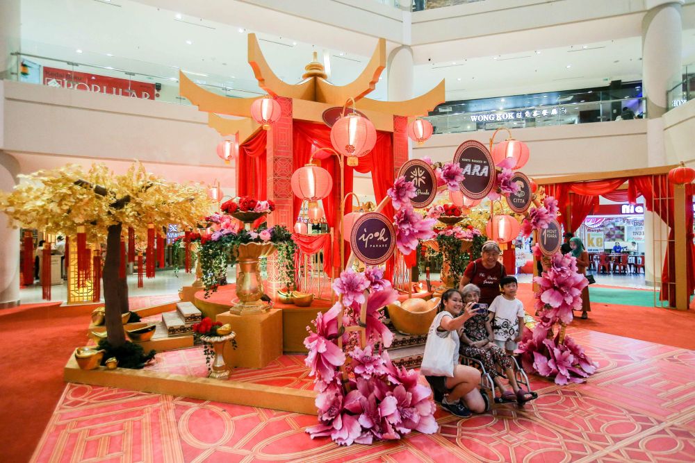The main court at Aeon Mall Ipoh Klebang has been turned into a garden with pink cherry blossoms and yellow and pink chrysanthemums. — Picture by Farhan Najib
