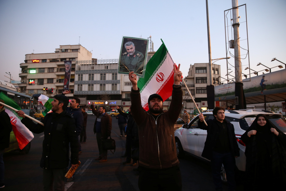A man holds a picture of late Iranian Major-General Qassem Soleimani, as people celebrate in the street after Iran launched missiles at US-led forces in Iraq, in Tehran, Iran January 8, 2020. u00e2u20acu201d Nazanin Tabatabaee/WANA (West Asia News Agency) pic via Reu