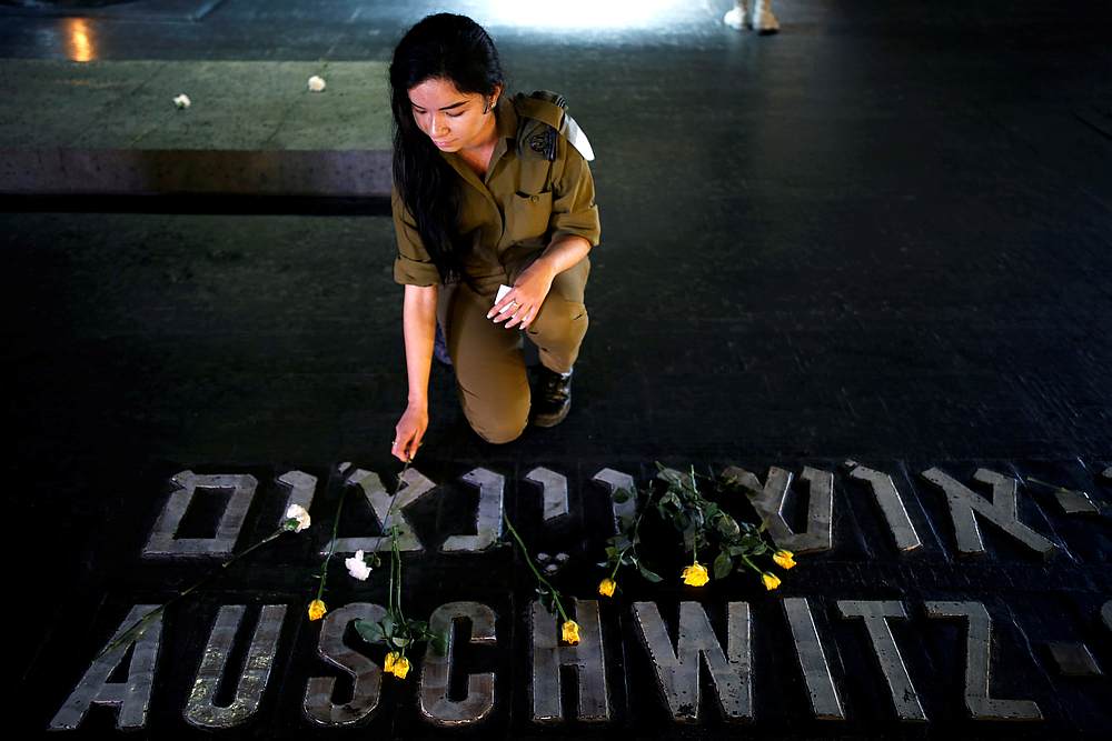 An Israeli soldier places a flower next to the name of a former death camp as she visits the Hall of Remembrance on the annual Israeli Holocaust Remembrance Day in Jerusalem April 12, 2018. u00e2u20acu201d Reuters pic