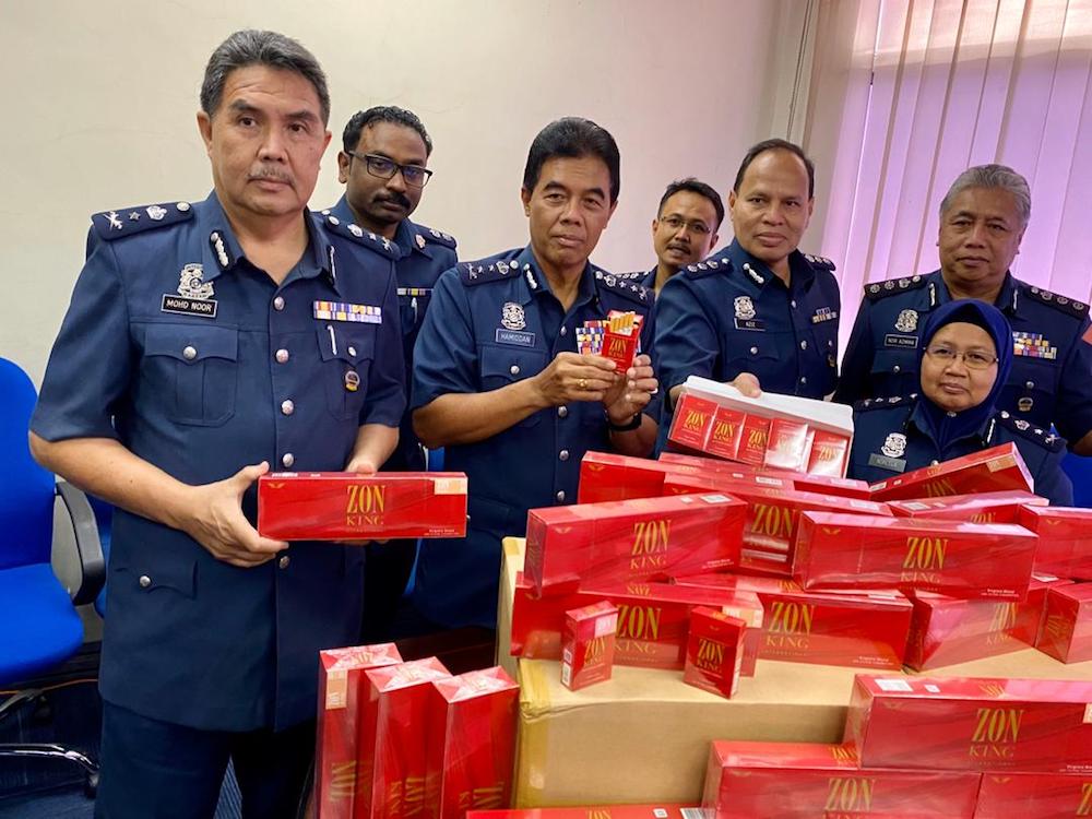 Johor Customs Department director Datuk Mohammad Hamidan Maryani (centre) with the seized contraband cigarettes during a press conference at the Gelang Patah Customs Enforcement Division office at the Sultan Abu Bakar Complex (KSAB) in Gelang Patah.