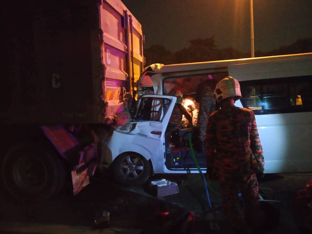 In the aftermath of the collision, the front of the van is seen lodged into the rear of the 30-tonne lorry. — Picture courtesy of Selangor Fire and Rescue Department