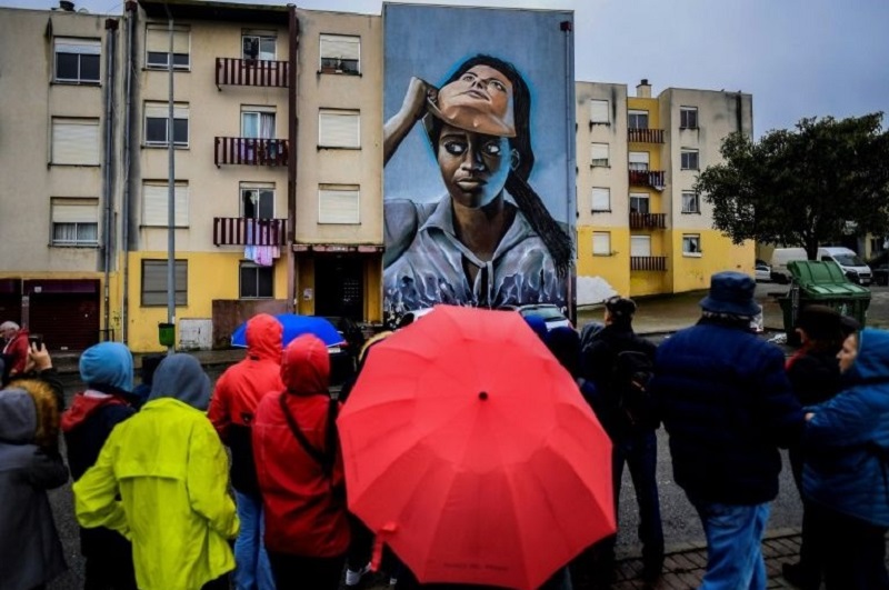 Visitors watch a mural by Portuguese-Angolan artist Nomen during a guided visit to Quinta do Mocho neighbourhood in Sacavem, outskirts of Lisbon November 11, 2019. u00e2u20acu201d AFP pic