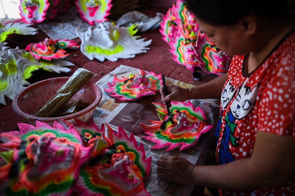 This picture taken on January 17, 2020 shows a worker preparing dragon figure decorations for giant incense sticks at a factory ahead of the Lunar New Year celebrations in Kubang Semang, Penang. — AFP pic