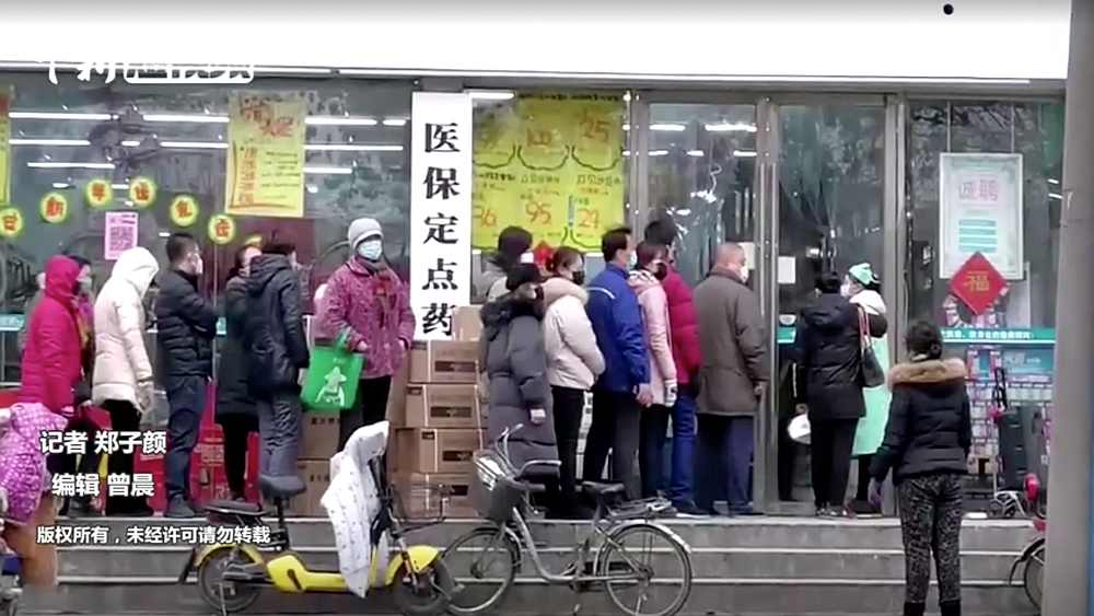 People wearing masks queue at a shop in Wuhan, Hubei province, China January 23, 2020. u00e2u20acu201d China News Service video image via Reuters