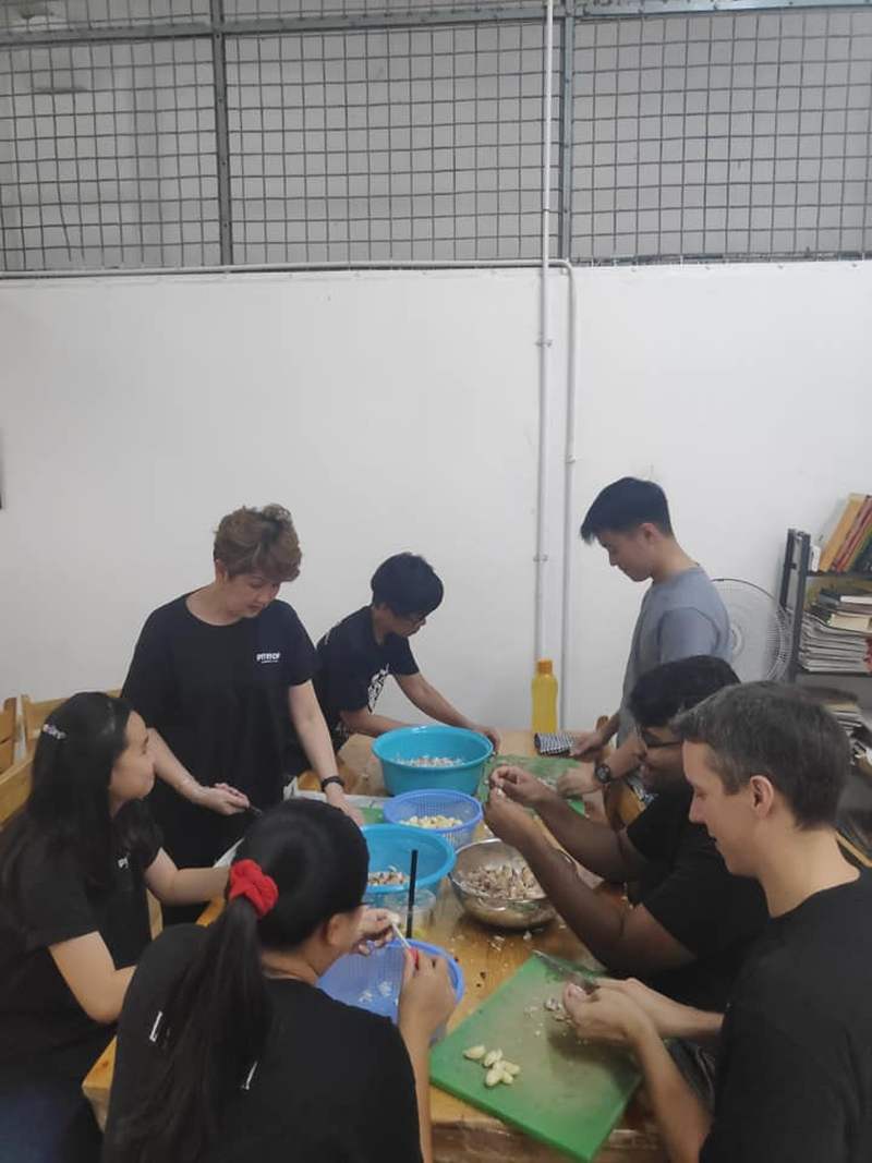 Volunteers help with vegetable prep such as peeling and slicing garlic. ― Picture via Facebook/Pit Stop Community Cafe