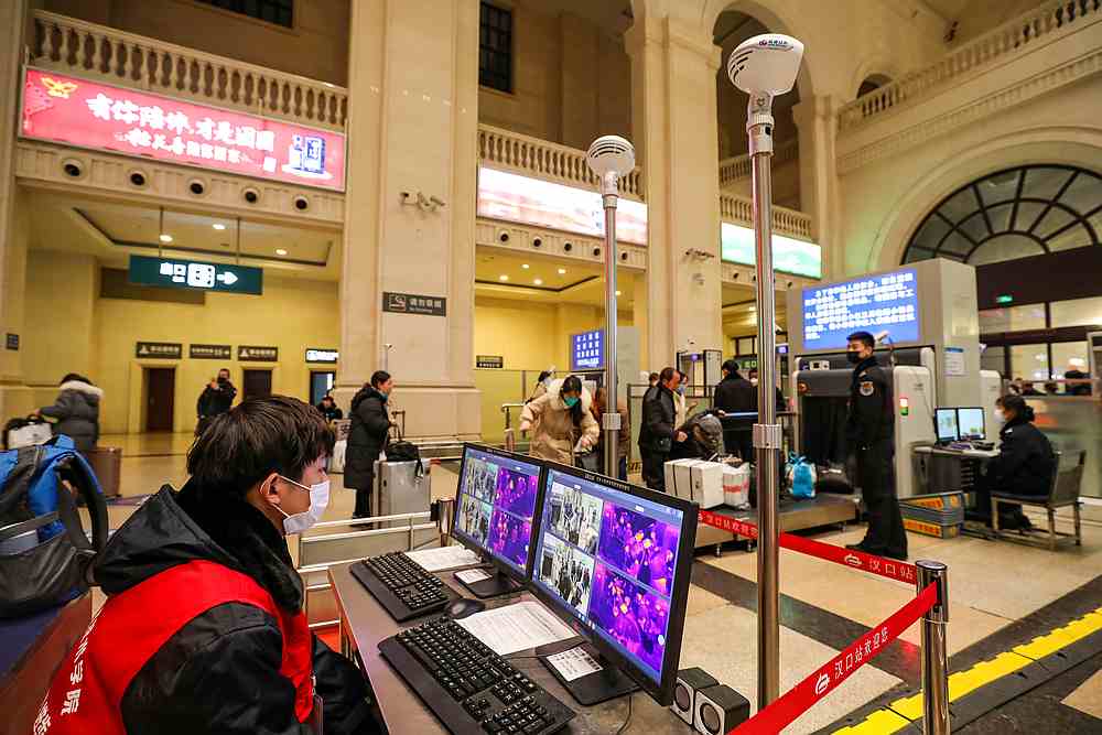 Staff members wearing masks monitor thermal scanners that detect temperatures of passengers at the Hankou Railway Station in Wuhan, Hubei province, China January 21, 2020. u00e2u20acu201d China Daily pic via Reuters