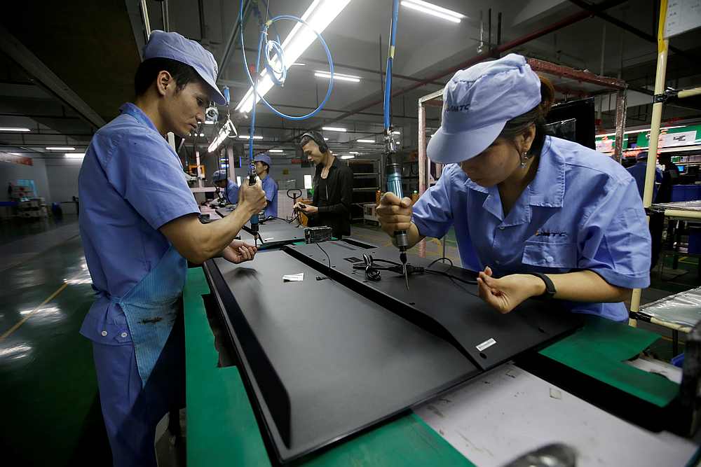 Employees work on the production line of a television factory under Zhaochi Group in Shenzhen, China August 8, 2019. u00e2u20acu201d Reuters pic