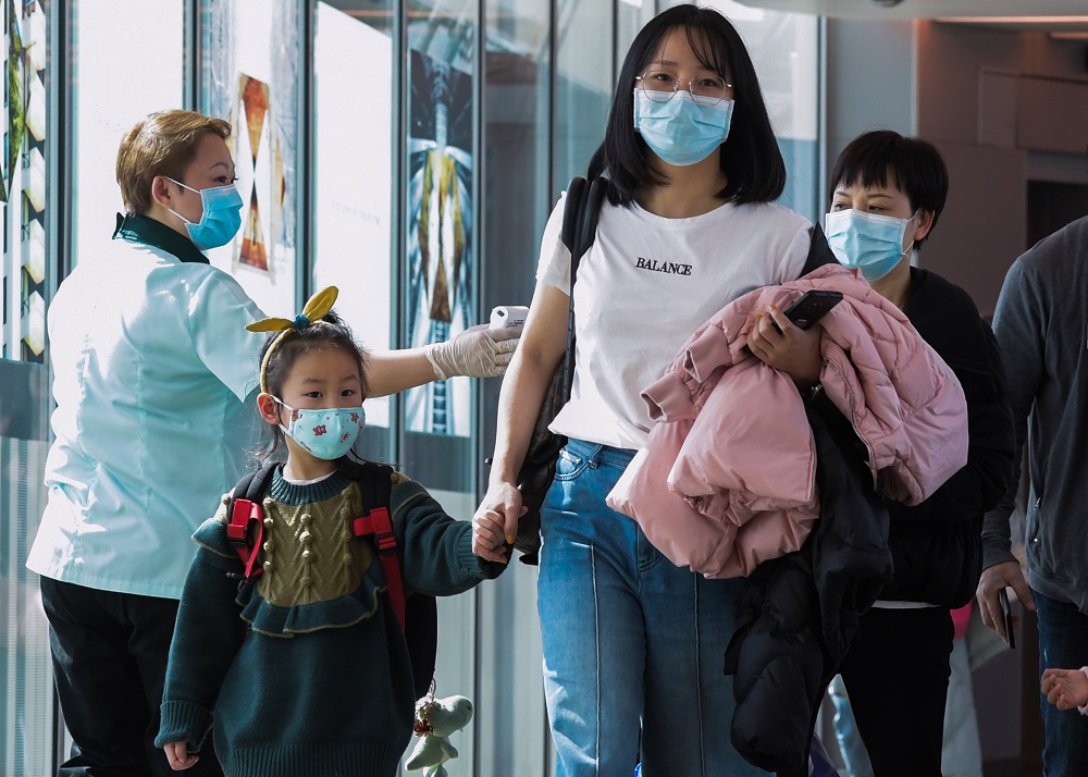 A health officer screens arriving passengers from China at Changi International airport in Singapore on January 22, 2020, as authorities increased measure against coronavirus. u00e2u20acu201d AFP pic