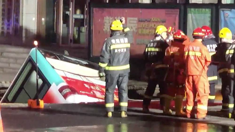 Image from the YouTube video: Bus crashes into sinkhole as road collapses in Xining City. 
