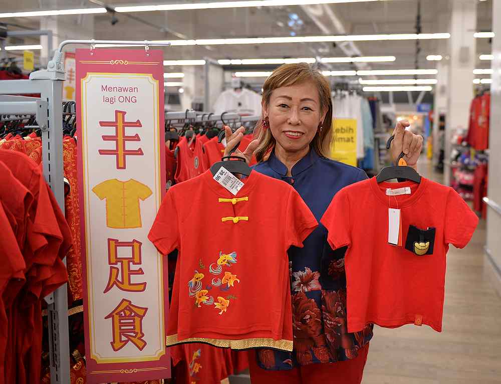 Tesco Malaysia customer director Vivian Yap showing off the traditional Chinese attire, among items for the ‘Semua ONG Mali 2020’ campaign. — Picture courtesy of Tesco Malaysia 