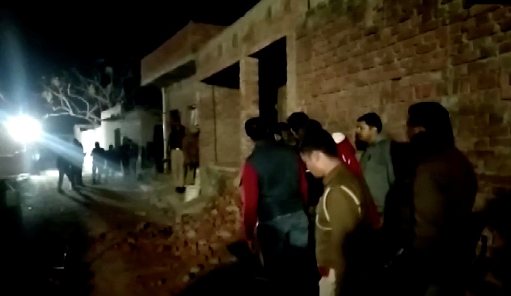 Residents and police personnel stand outside the building where a man has held hostages in Farrukhabad, Uttar Pradesh, India January 30, 2020. u00e2u20acu201d ANI video image via Reuters