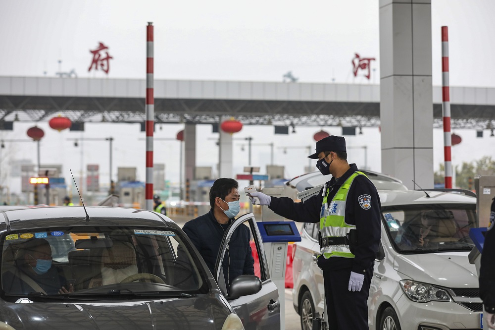 A police officer checks the temperature of a driver at a highway in Wuhan, in China's central Hubei province January 24, 2020. u00e2u20acu201d AFP pic 