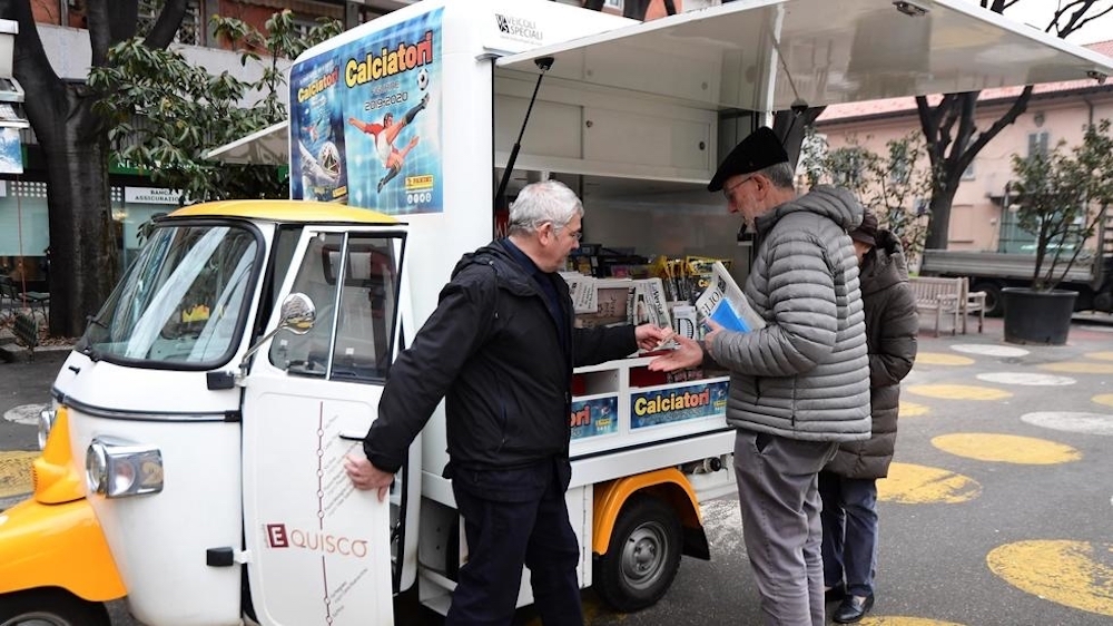 People buy newspapers and magazines at Andrea Carbini's (left) three-wheeled transporter newsstand during his daily itinerary in different points of Milan January 25, 2020. u00e2u20acu201d AFP pic