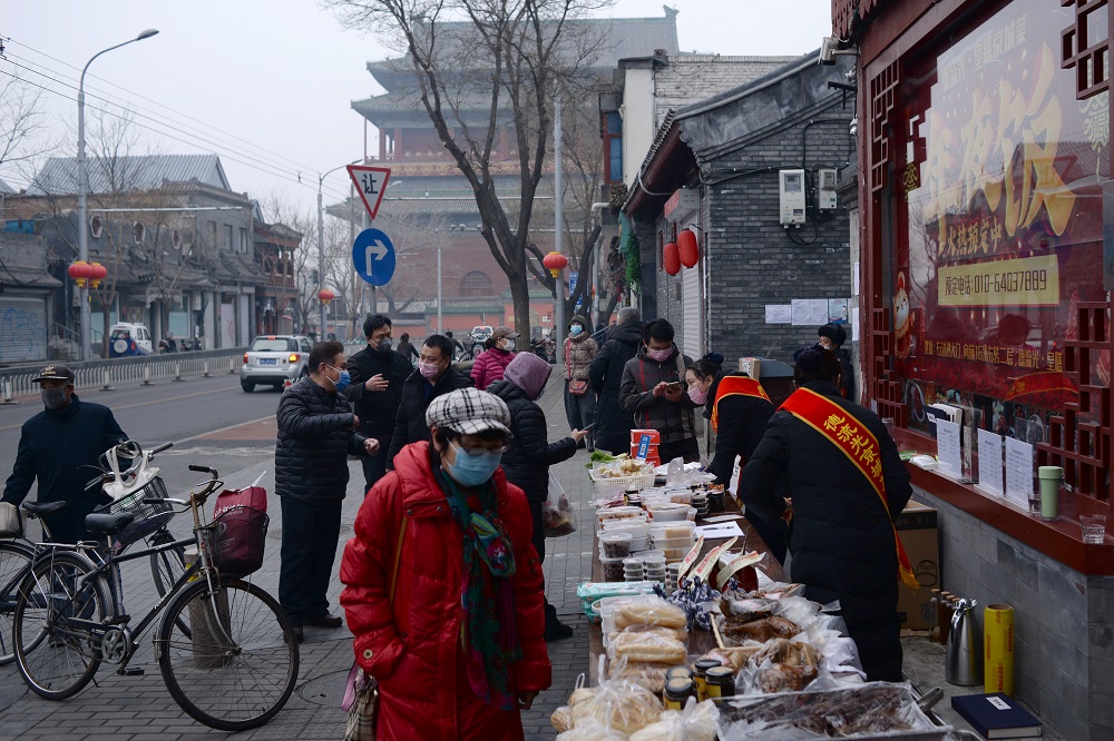 People wearing face masks buy food from a stall set up by a restaurant outside its outlet in central Beijing February 13, 2020. u00e2u20acu201d Reuters pic