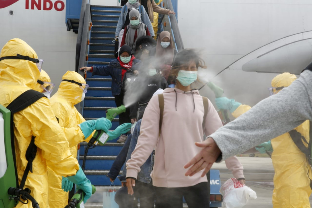 Medical officers spray Indonesian nationals with antiseptic after they arrived from Wuhan, China center of the coronavirus epidemic, before transferring them to the Natuna Islands military base to be quarantine, February 2, 2020. u00e2u20acu201d Antara Foto pic via R