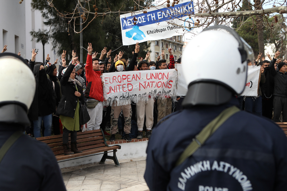 Riot police stand guard as refugees and migrants demonstrate outside the municipal theatre of the city of Mytilene, on the island of Lesbos, Greece, February 4, 2020. u00e2u20acu201d Reuters picnn