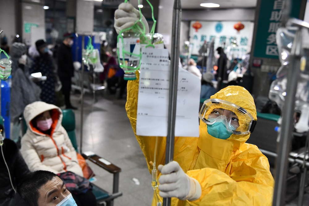 A medical worker in protective suit adjusts a drip bag for a patient at a hospital, following an outbreak of the new coronavirus in Wuhan, Hubei province February 3, 2020. u00e2u20acu201d Reuters pic