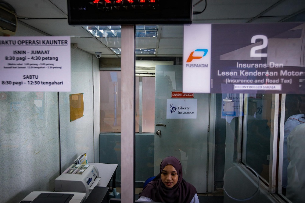 A staff is seen at one of the service counters located at the Wangsa Maju Puspakom branch in Kuala Lumpur February 7, 2020. u00e2u20acu201d Picture by Hari Anggara