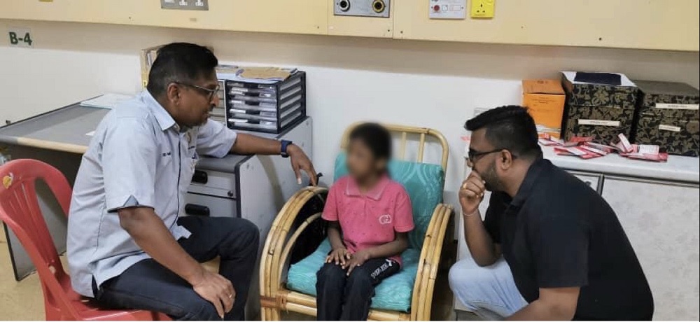Tamilar Kular president P. David Marshel (left) and Bagan Dalam assemblyman M. Satees speak to the abused child during their meeting in George Town February 10, 2020. u00e2u20acu201d Picture courtesy of P. David Marshel