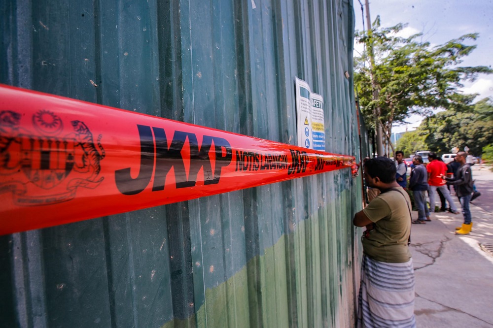 Construction workers stand outside the site The Address condominium project site in Taman Desa February 15, 2020. u00e2u20acu201d Picture by Hari Anggara