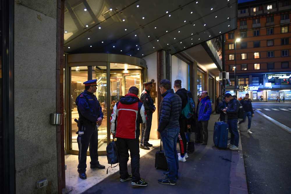 Policemen guard the entrance of the Grand Hotel Europa as people with luggage wait outside, after authorities put the Hotel under isolation as an employee was tested positive on the new coronavirus in Austria, in Innsbruck, Austria February 25, 2020. u00e2u20acu2022 