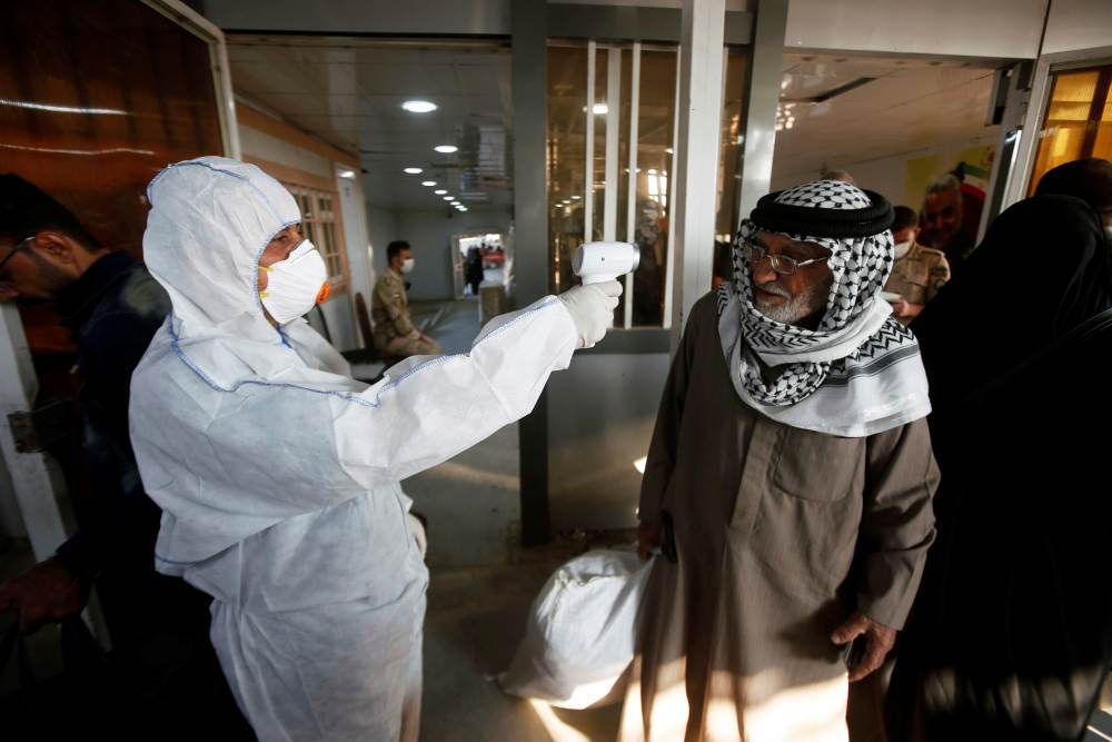 An Iraqi medical staff member checks a passenger's temperature, amid the new coronavirus outbreak, upon his arrival to Shalamcha Border Crossing between Iraq and Iran February 20, 2020. u00e2u20acu2022 Reuters pic