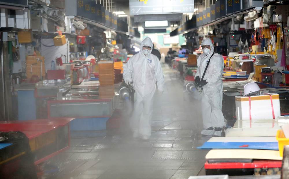Employees from a disinfection service company sanitize at a fish market in Busan, South Korea February 25, 2020. u00e2u20acu2022 Handout via Reuters