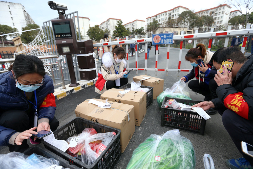 Volunteers and community workers deliver vegetables and goods to residents inside a residential compound at its entrance, in Xiangyang city of Hubei, the province hit hardest by the novel coronavirus outbreak, China February 20, 2020. — Reuters pic