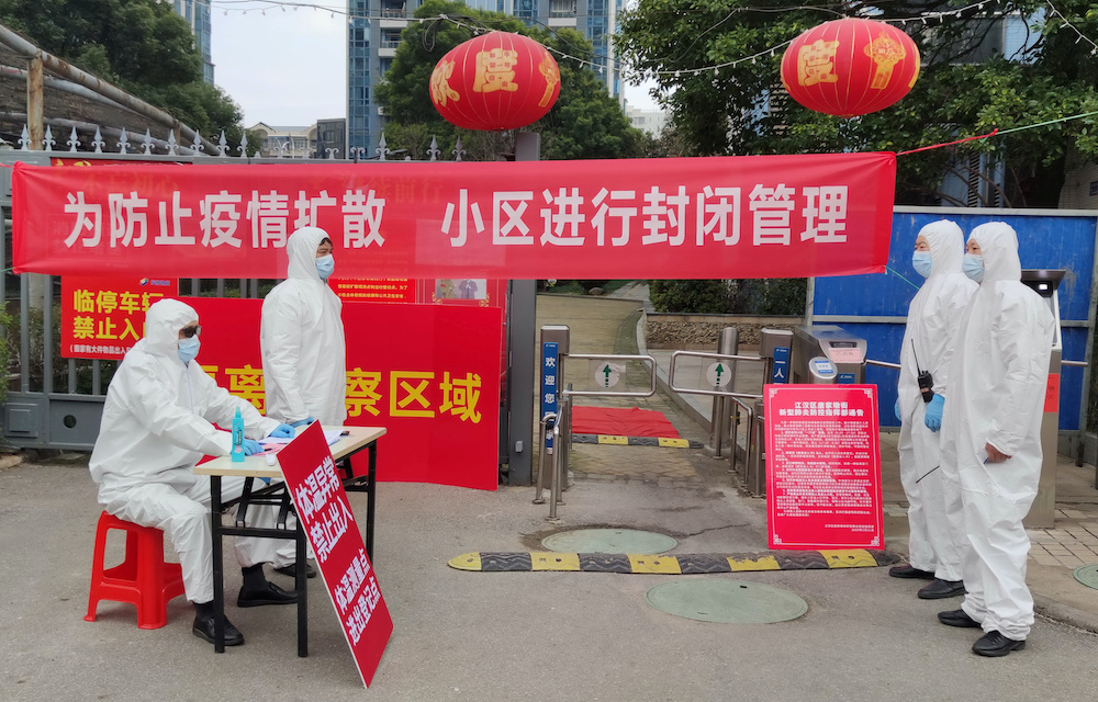 Workers in protective suits are seen at a checkpoint for registration and body temperature measurement, at an entrance to a residential compound in Wuhan, the epicentre of the novel coronavirus outbreak, in Hubei province, China February 13, 2020. — Reu