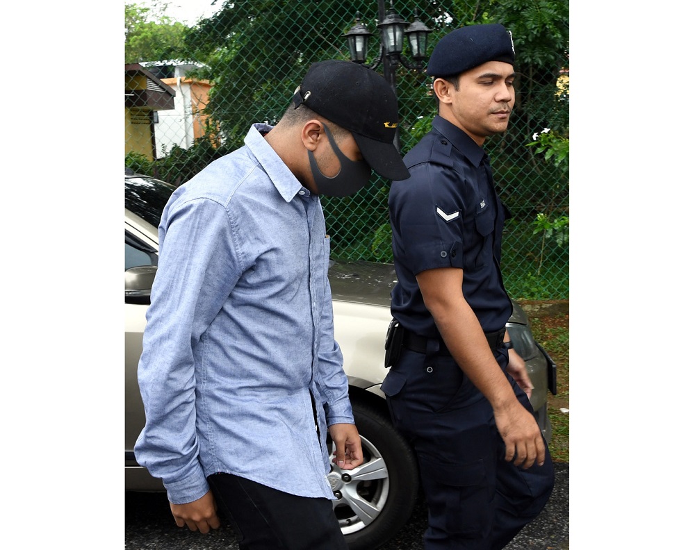 Nabil Hariz Jefridin (left) is led to the Magistrateu00e2u20acu2122s Court in Rembau February 18, 2020. u00e2u20acu201d Bernama pic
